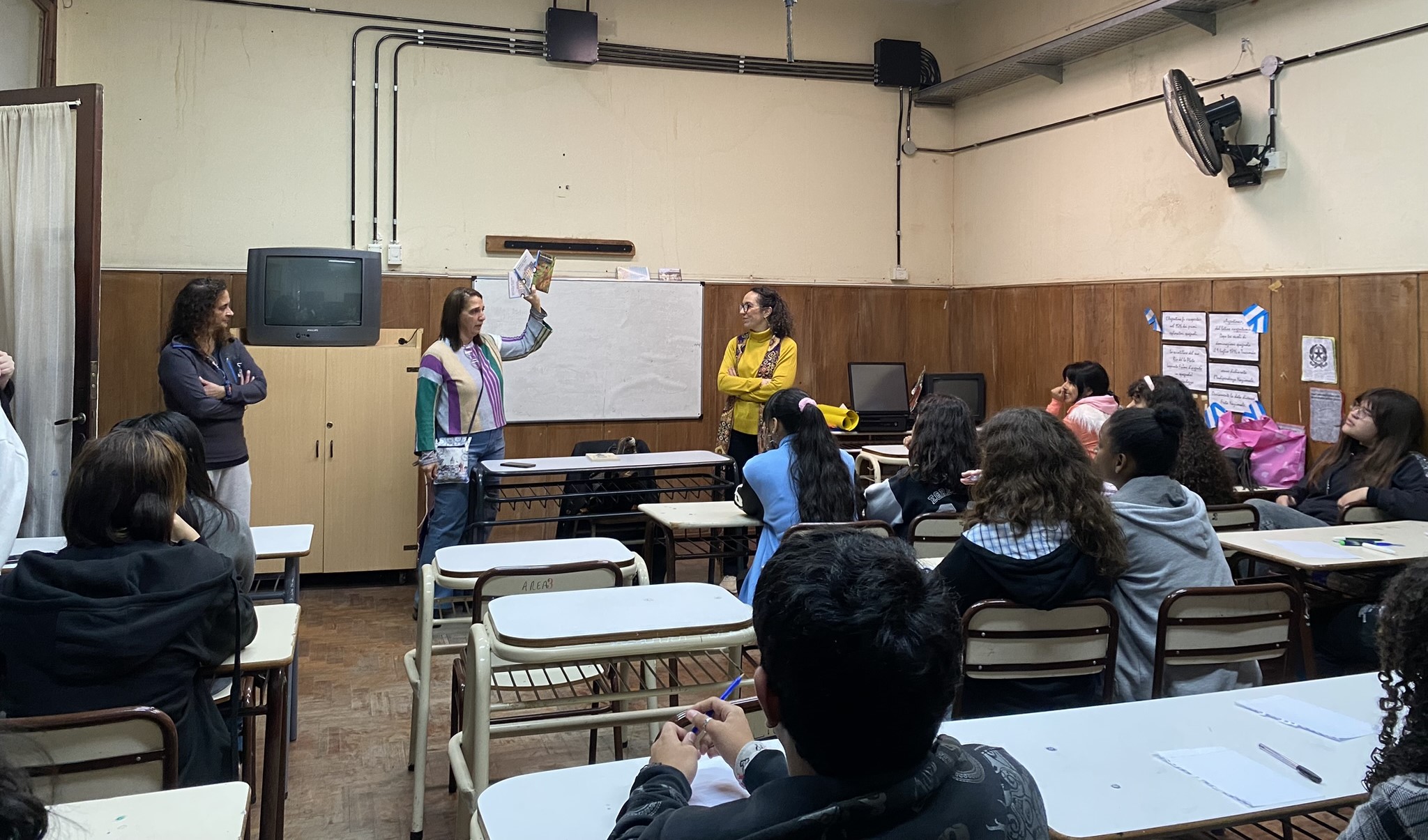La Vicerrectora del turno de la mañana agradece y muestra a los estudiantes la donación de tres libros por parte de la escritora Alejandra Jaramillo. Autor: Prensa de la Embajada de Colombia.